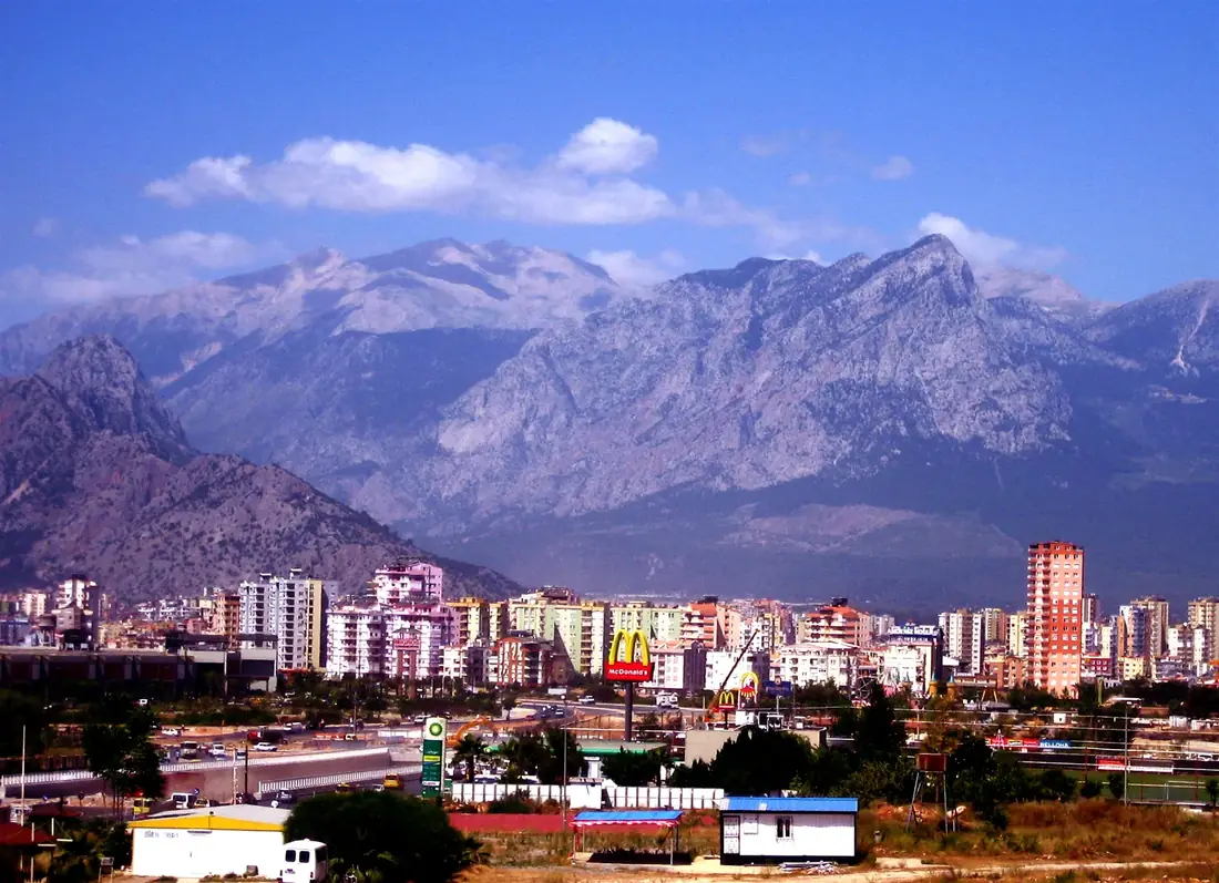 A city below snow-capped mountains