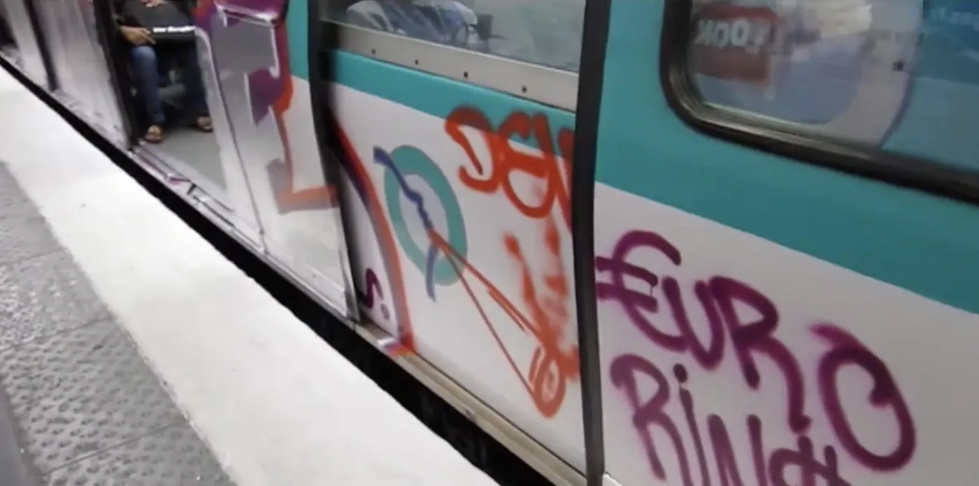 A graffiti-covered Paris metro train at the platform